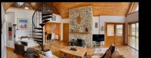 a living room with a stone fireplace and a spiral staircase at Drumcoura Dreamescape in Ballinamore