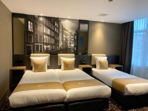 ein Hotelzimmer mit zwei Betten und einem Fenster in der Unterkunft XO Hotels Infinity in Amsterdam