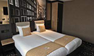 een slaapkamer met een groot bed met witte lakens en kussens bij XO Hotels Infinity in Amsterdam