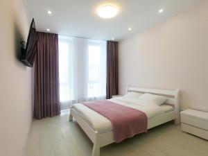 - une chambre avec un lit et une grande fenêtre dans l'établissement Elite apartments in the center of Lviv, à Lviv