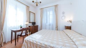 a bedroom with a bed and a desk and a window at BORGO COLLE RIDENTE 13, Emma Villas in Camerino +43 photos