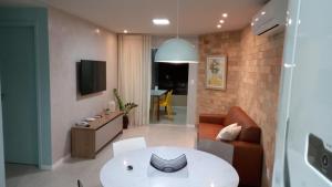 a living room with a couch and a table at GUARAJUBA - Apartamento MÁXIMO 4 PESSOAS -2 quartos - 170 m da praia in Guarajuba