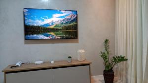 a flat screen tv hanging on a wall in a room at GUARAJUBA - Apartamento MÁXIMO 4 PESSOAS -2 quartos - 170 m da praia in Guarajuba +8 photos
