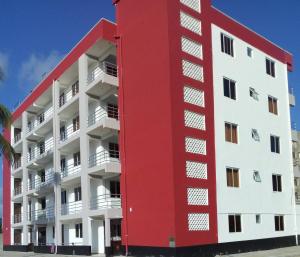 ein rot-weißes Apartmenthaus in der Unterkunft Mtwapa Pride Apartment 4th Floor in Mtwapa