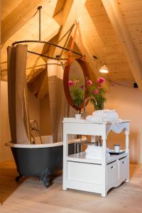 a bathroom with a black tub and a white table at Hotel De Londres in Brig