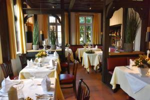 a restaurant with tables with white tablecloths at Klosterschänke Hude Hotel Ferienwohnungen Restaurant Café in Hude