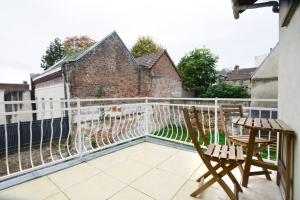 einen Balkon mit zwei Stühlen und einem Zaun in der Unterkunft Heptagone_1 in Saint-Quentin