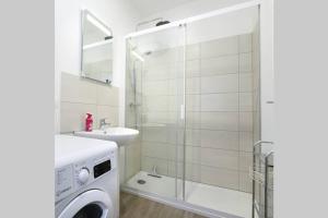 ein Badezimmer mit Waschmaschine und Dusche in der Unterkunft Heptagone_1 in Saint-Quentin