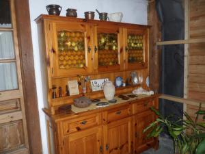 a wooden cabinet filled with lots of glass at La vieille maison Biselli in Tende