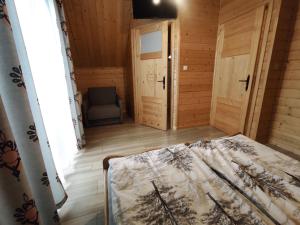 a bedroom with a bed and a chair in a room at Domki Pienińskie in Szczawnica