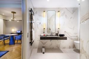 a bathroom with a sink and a mirror at Fraser Suites Le Claridge Champs-Elysées in Paris