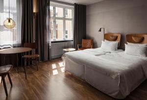 a bedroom with a large white bed and a table at Hotel SP34 by Brøchner Hotels in Copenhagen