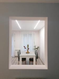 een witte eetkamer met een tafel en stoelen bij Apartamentos El Cid in Molina de Aragón