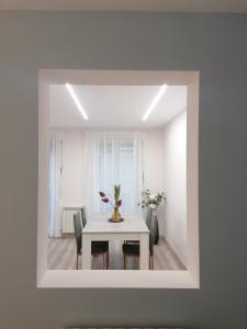 a white dining room with a table and chairs at Apartamentos El Cid in Molina de Aragón