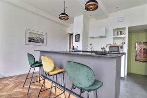 a kitchen with three bar stools and a counter at Appartement entier - refait à neuf - Loft - City Center in Lyon