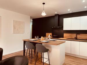 a kitchen with a island with bar stools at L'Appart'à-G in Gérardmer