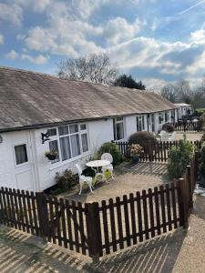 una casa blanca con una mesa y sillas frente a ella en Sheephouse Manor en Maidenhead