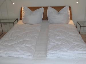 a bed with white sheets and pillows at Speicher Residenz Barth E7 App 1 in Barth