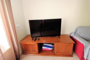 einen Flachbild-TV auf einem Holztisch in der Unterkunft Open Space - Albufeira in Albufeira