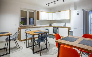 a kitchen with tables and chairs and a refrigerator at Marathon Noclegi in Skarżysko-Kamienna