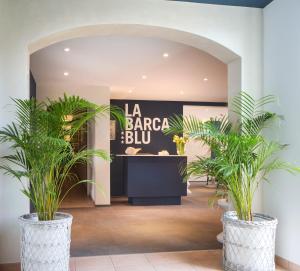 a store with two potted plants in a lobby at La Barca Blu in Locarno