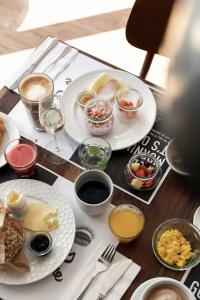 a table with plates of food and drinks on it at Hotel SP34 by Brøchner Hotels in Copenhagen