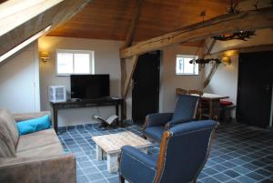 a living room with a couch and chairs and a table at Boerensuite, heerlijk verblijf in het Karschop in Riel