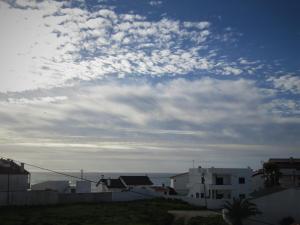 um céu nublado sobre as casas e o oceano em Pedras do Mar - Consolação - Peniche na Consolação