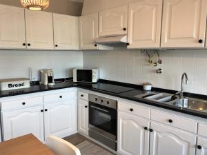 a kitchen with white cabinets and a sink at Pedras do Mar - Consolação - Peniche in Consolacao