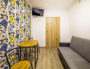 a living room with a couch and a table and chairs at Marathon Noclegi in Skarżysko-Kamienna