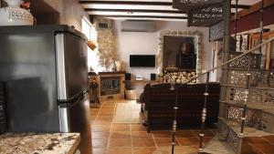 a kitchen with a refrigerator and a living room at El Rincón de San José in Marjaliza