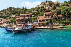 two boats are docked in the water near a village at KARABİBİK BUNGALOW in Demre