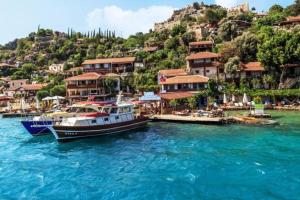 twee boten zijn aangemeerd in het water bij een dorp bij KARABİBİK BUNGALOW in Demre