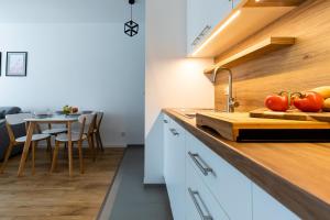 a kitchen with a counter with tomatoes on a cutting board at Symphony Baltica Towers Apartamenty by INA in Gdańsk +263 photos