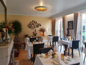 een eetkamer met witte tafels en stoelen en een restaurant bij Notarishuis Beveren B&B in Beveren