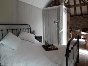 Un dormitorio con una cama blanca y una bandeja. en Countryside tiny house near Chateau de Hautefort, en Boisseuilh