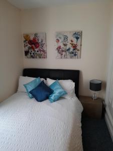 a bedroom with a bed with two paintings on the wall at 17 Foss Street in Dartmouth