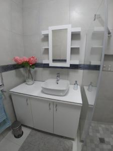a white bathroom with a sink and a mirror at Protea Suite in Bellville