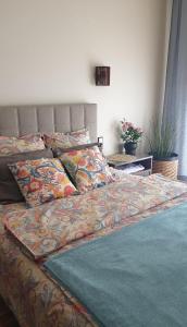 a bed with a comforter and pillows on it at Apartament MODERNA Francuska Park in Katowice