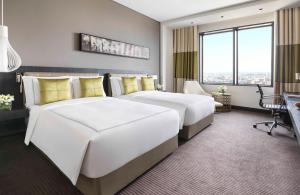 a hotel room with two beds and a desk at Fairmont Riyadh in Riyadh