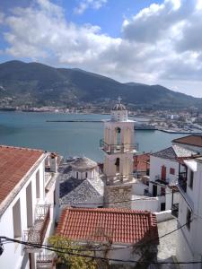 een uitzicht op het water vanuit een stad met een klokkentoren bij House of town in Skopelos Town