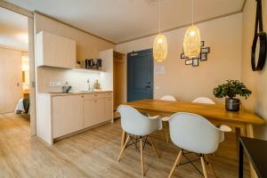 una cucina e una sala da pranzo con tavolo in legno e sedie bianche di Mere 38 Apartments a Võsu
