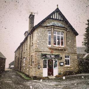 an old stone building in the snow in front at The Tors in Okehampton
