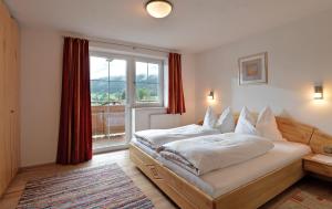 een slaapkamer met een bed en een groot raam bij Appartement Christine in Brixen im Thale