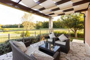 un patio esterno con tavolo e sedie in vimini di Villa Astra a Barban