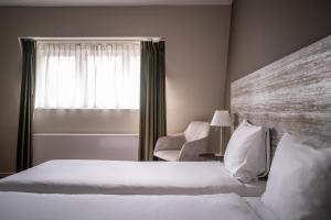 Postel nebo postele na pokoji v ubytování Hotel Au Quartier
