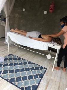 a man laying on a bed in a room at Casa praia Porto de Galinhas Toquinho in Ipojuca