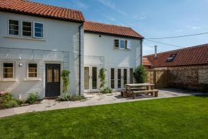 a house with a picnic table in the yard at Owl Cottage in Wighton