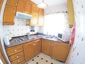 a kitchen with wooden cabinets and a sink and a microwave at Fleitas Penthouse with terrace in San Andrés