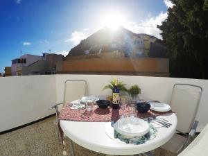 a table and chairs on a balcony with the sun at Fleitas Penthouse with terrace in San Andrés